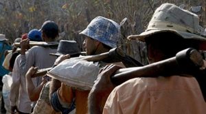 trabalhadores rurais com enxada nos ombros