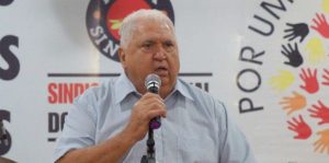 Presidente do sindicato dos aposentados falando no microfone durante evento